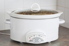 A slow cooker on a kitchen counter with the dial and settings visible