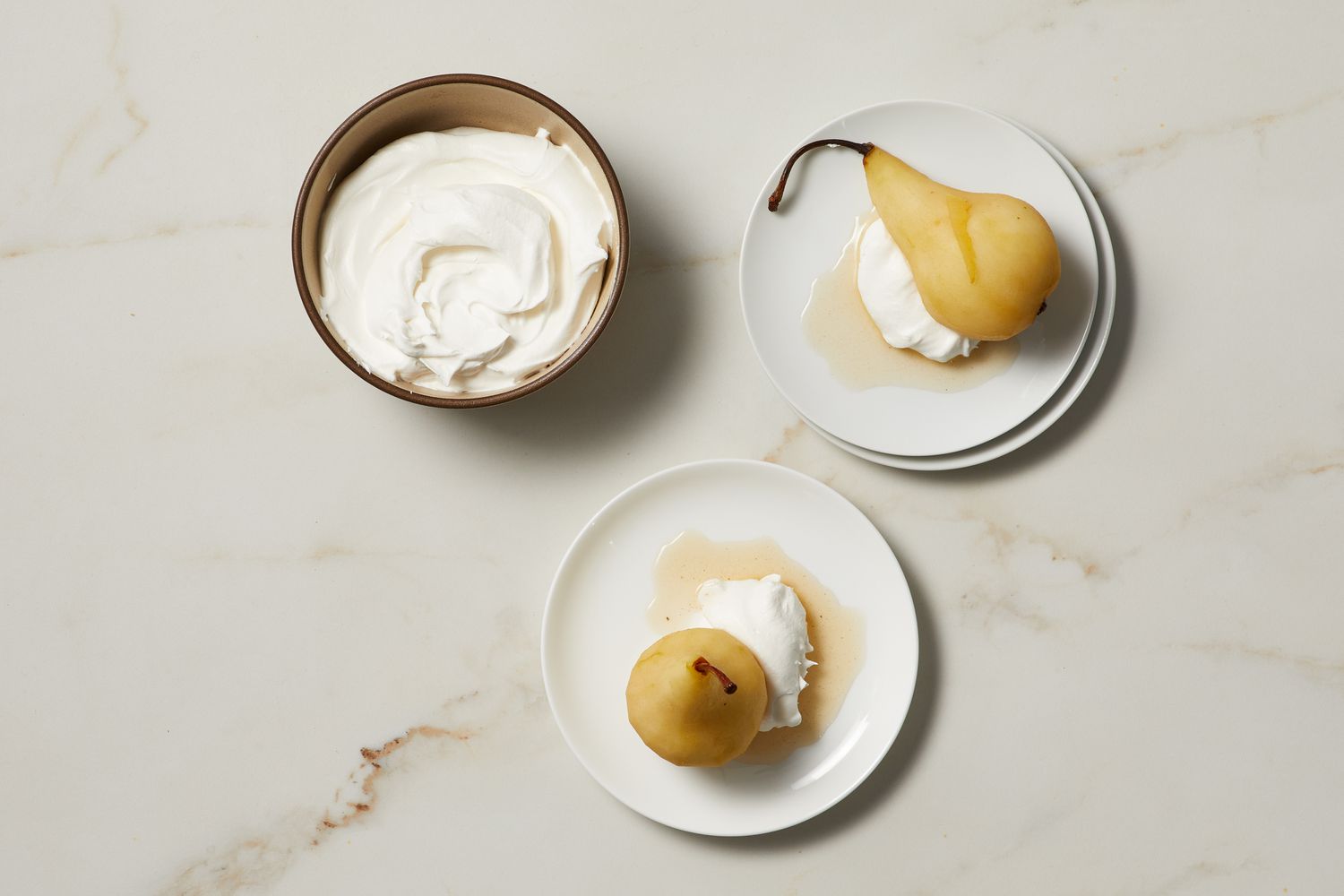 poached pears on plates with cream
