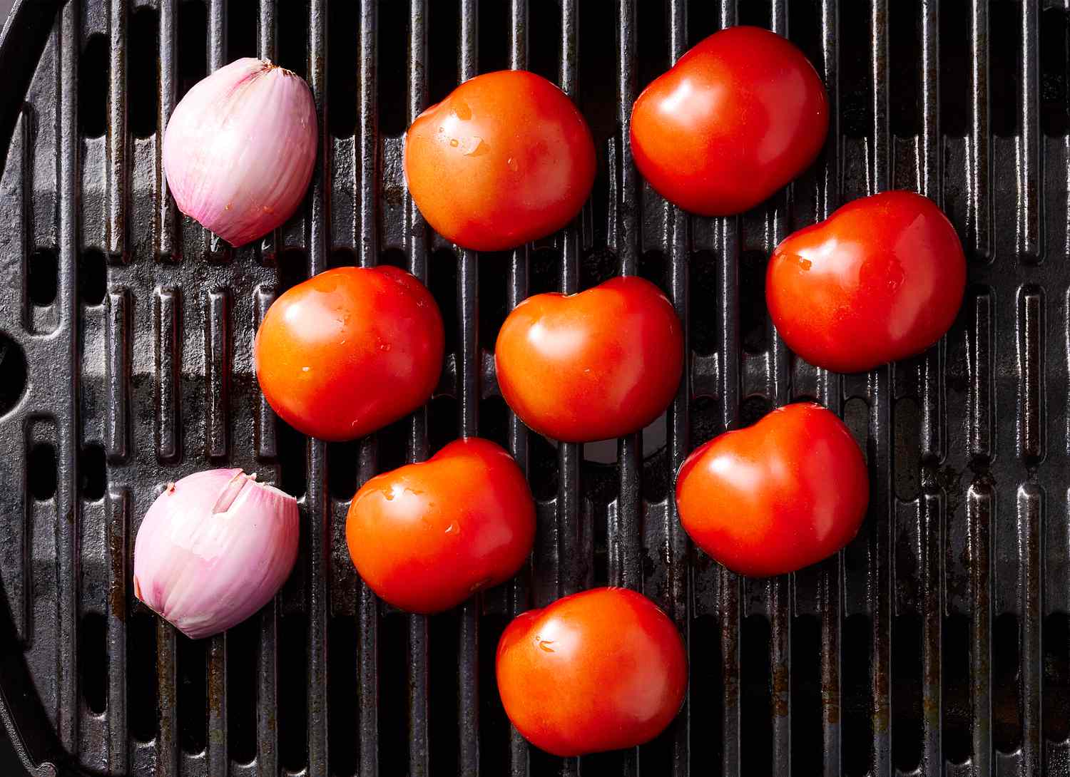 overhead view of tomatoes and onions on a grill