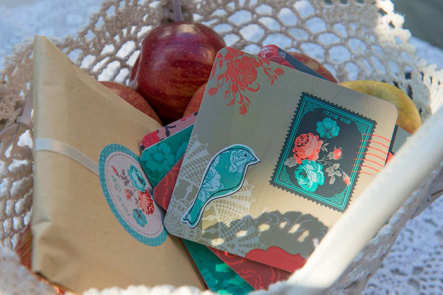A decorative basket with apples stationary and cards with bird and floral designs