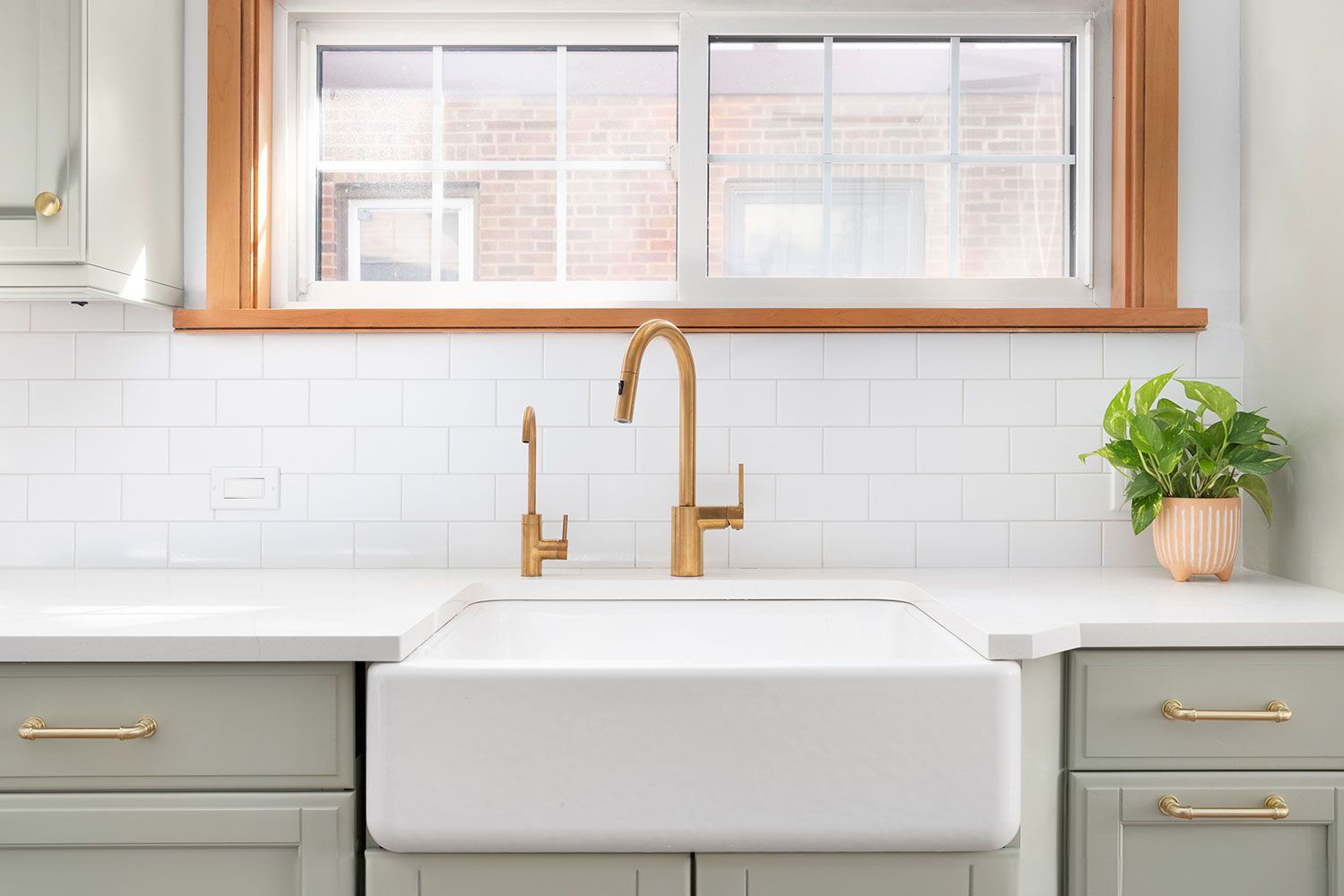 Kitchen with porcelain sink, gold faucet and switch for garbage disposal