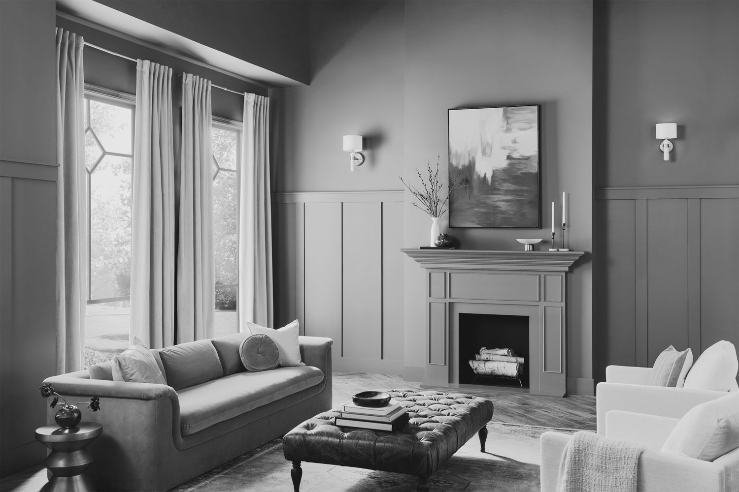 A living room with a sofa armchairs a fireplace and large windows