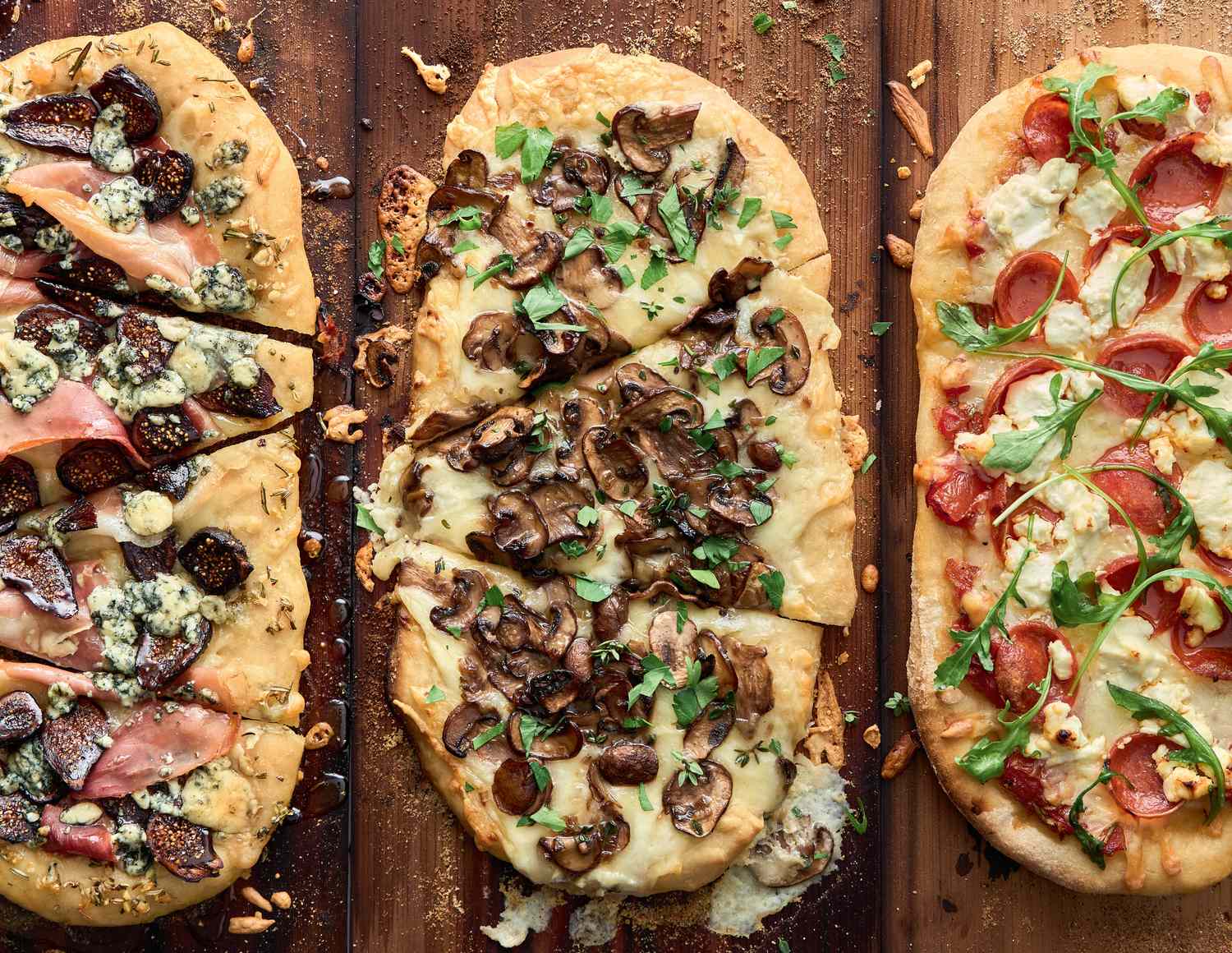 3 different pizzas on grilling planks