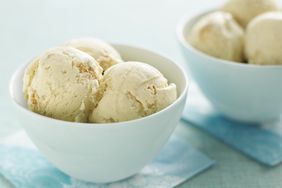 Two bowls filled with scoops of ice cream placed on bluepatterned napkins