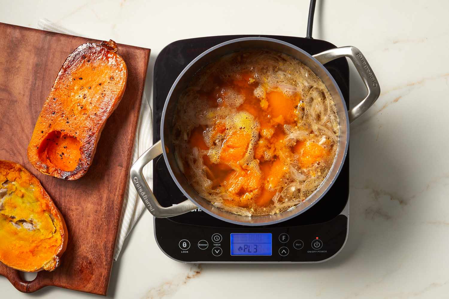 butternut squash halves next to cooking soup