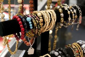 A display of various bracelets including beaded and metallic designs arranged on rods in a retail setting