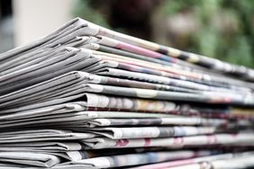 Stack of folded newspapers on a surface