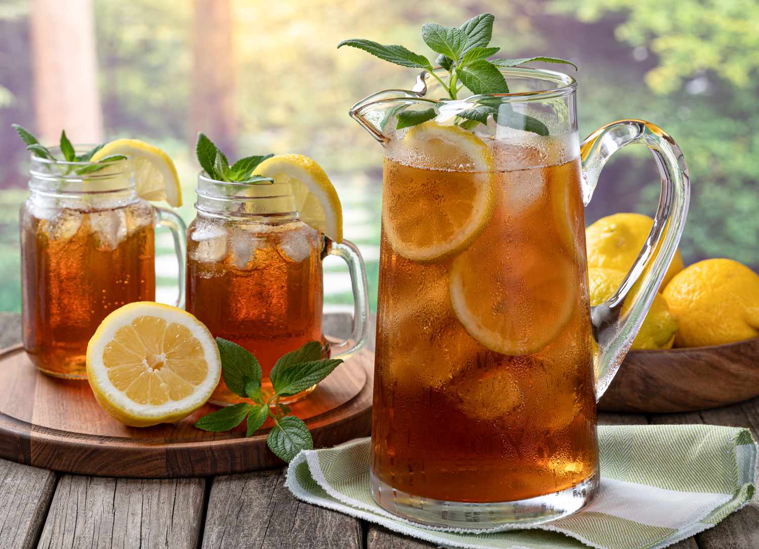 Pitcher of cold ice tea with rural summer background