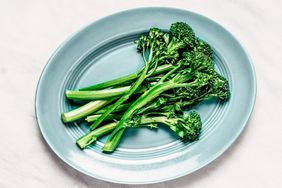 steam broccolini on blue blate