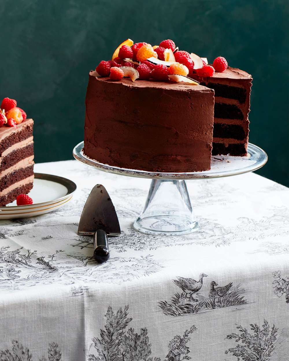 dairy-free chocolate-raspberry cake on glass cake stand
