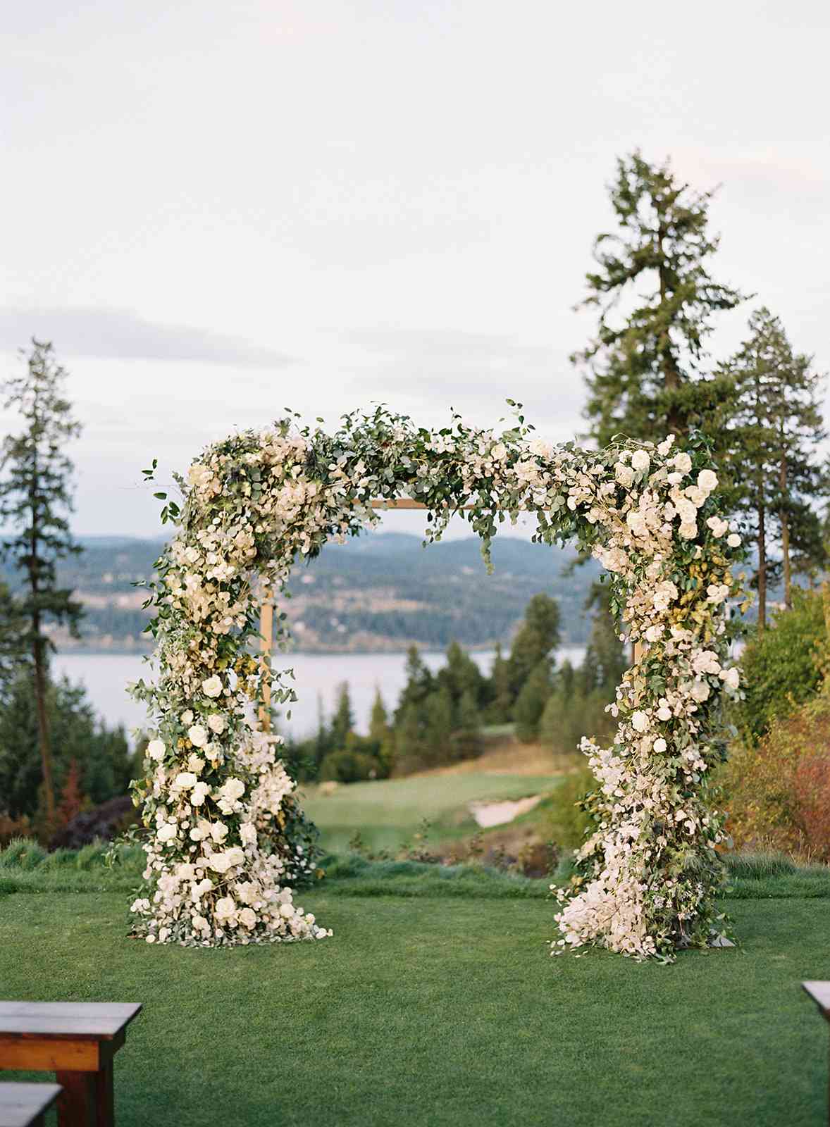 white floral and greenery wedding arch for outside ceremony