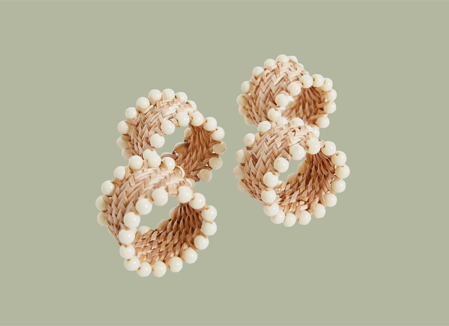 3 Rattan Beaded Napkin Rings on a green background