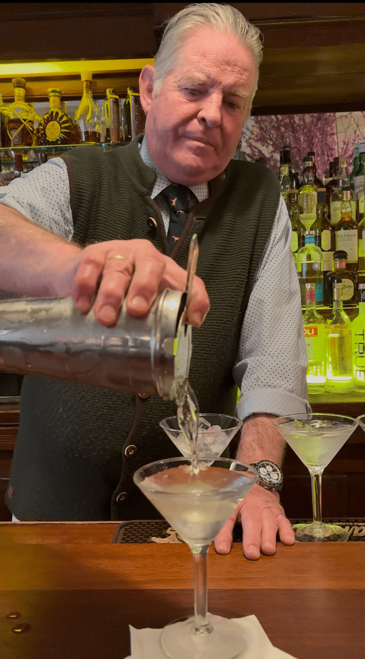 Bartender Brien at Elio's pouring a martini. 