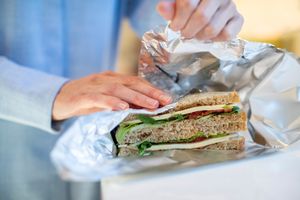 woman wrapping sandwich with aluminum foil