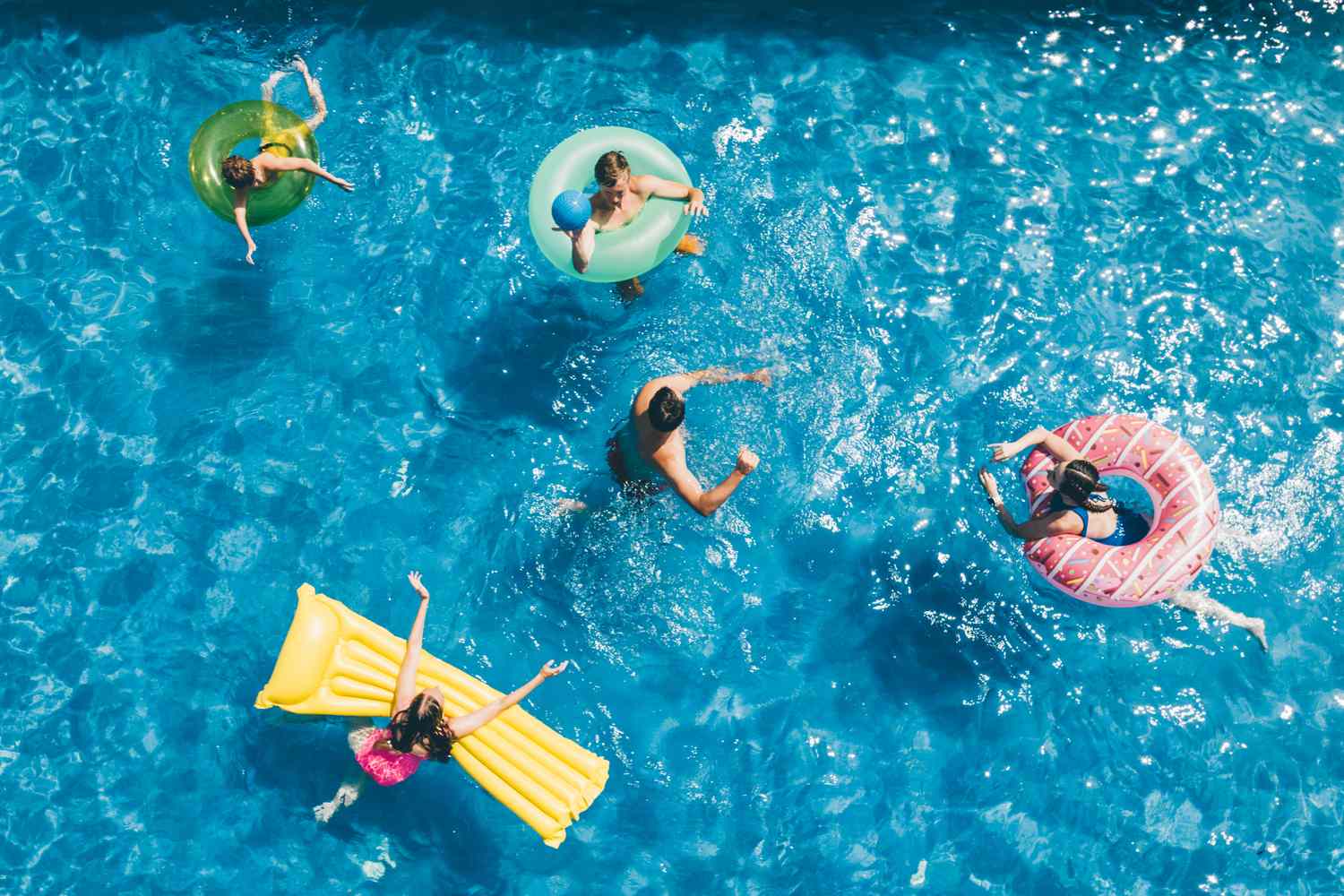 People swimming and floating on inflatables in a pool