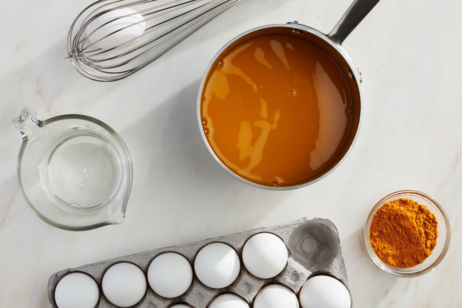 a carton of eggs and a pot with an orange powder mixture