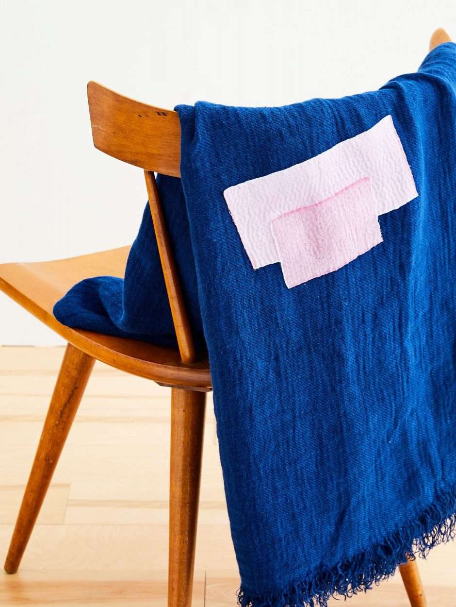 a mended blanket draped over a chair