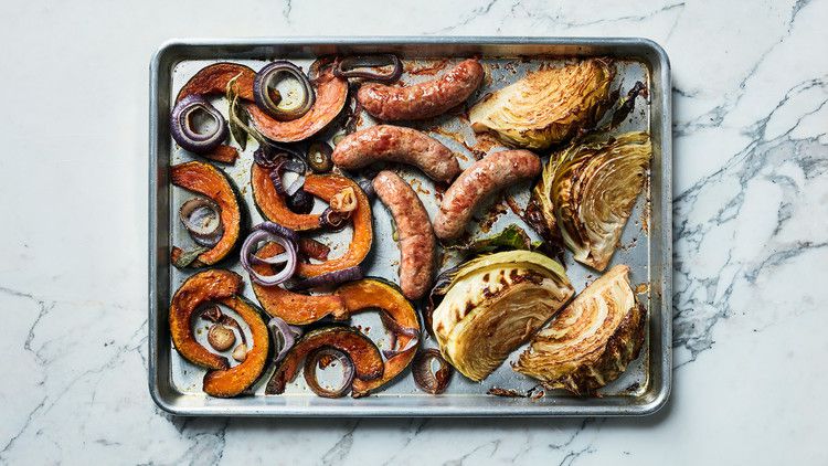 sausages cabbage vegetables on baking sheet