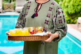 decorvow standing by pool holding cocktail tray