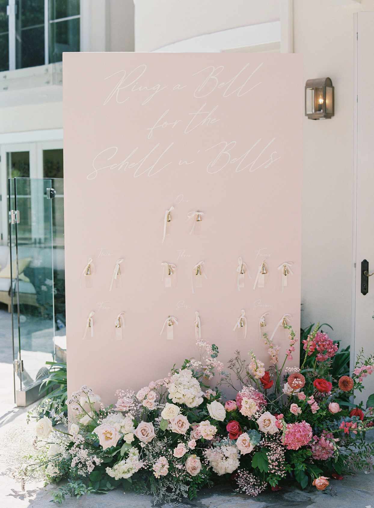 pink board with bell escort cards and floral detail