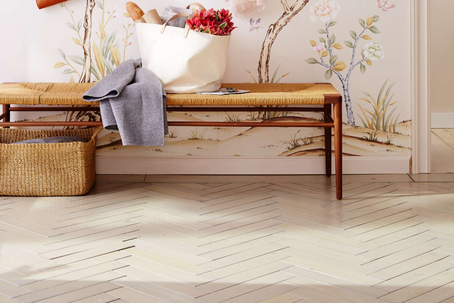 Herringbonepatterned floor bench with a basket and decor items floral wall artwork