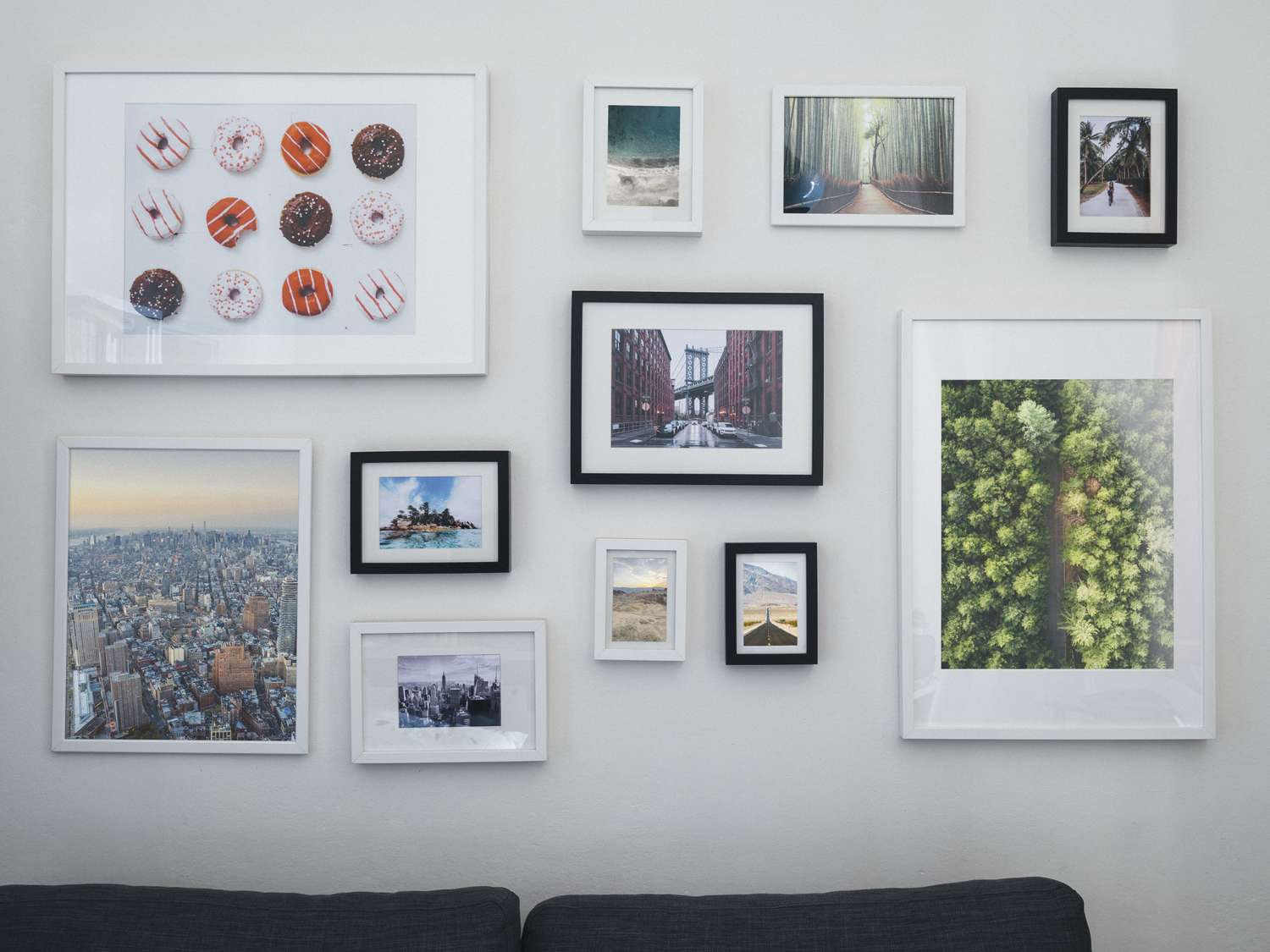 A living room wall with multiple framed artworks and photographs arranged in a decorative gallerystyle layout