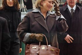 decorvow walking outside holding a Birkin bag accompanied by others