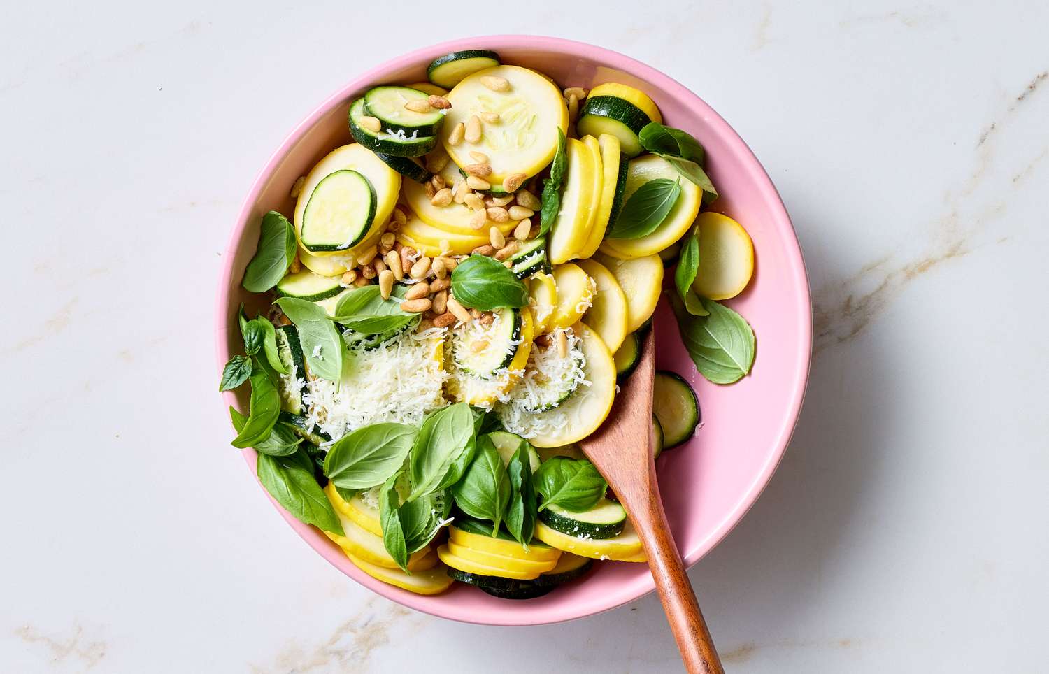 Zucchini and squash salad with pine nuts and basil in a bowl