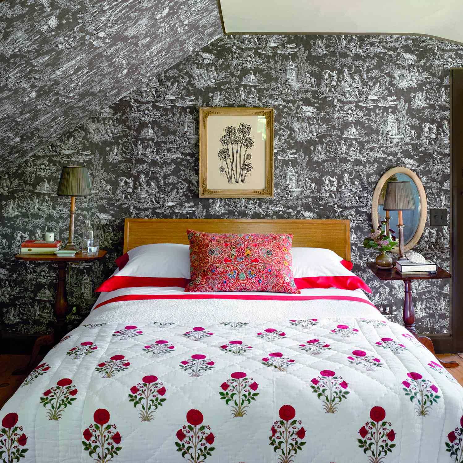 Bedroom featuring a decorative floral quilted bed cover framed artwork on the wall and matching bedside tables with lamps