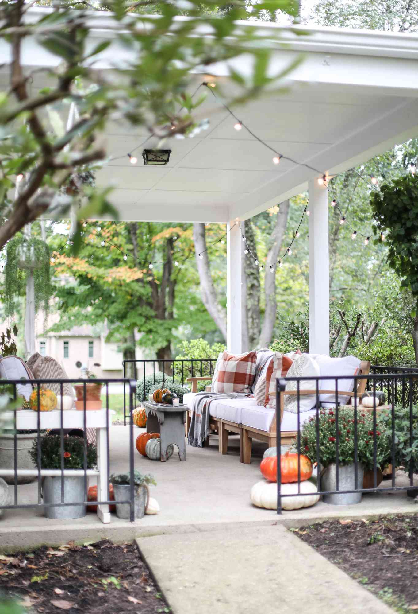 fall porch throw blankets twinkling lights pumpkins and mums