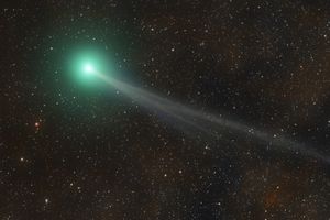A comet with a glowing head and a long tail in a starfilled space background
