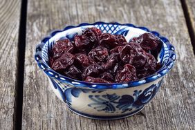 Bowl of dried cherries on a wooden surface