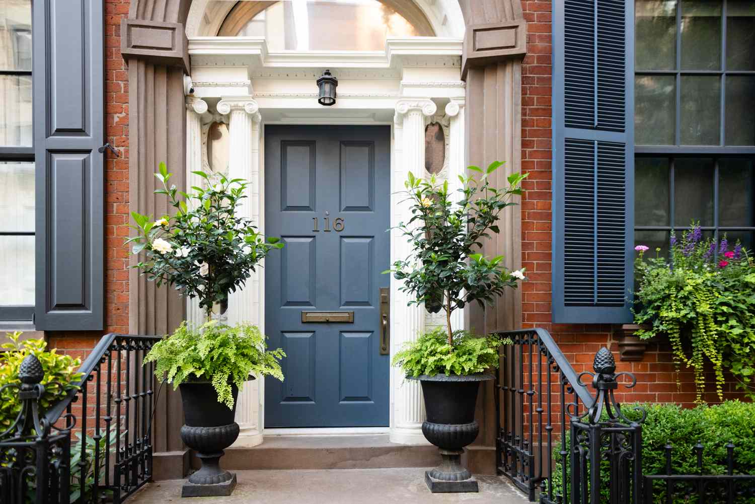 Elegant entrance to a building with plants flanking the main door