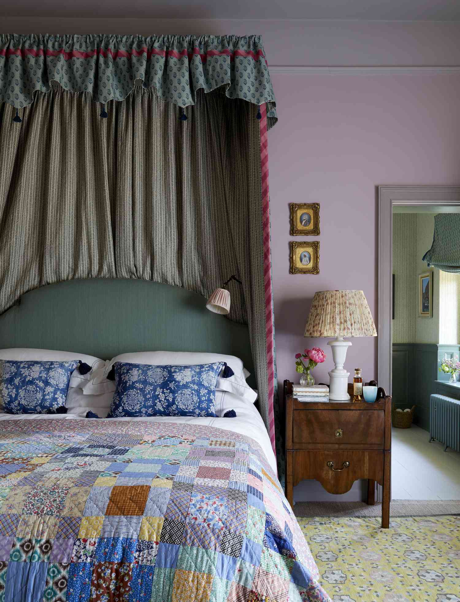 a bedroom with light purple walls and colorful prints