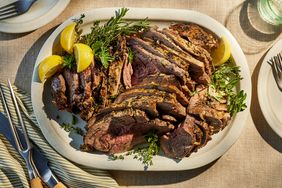 roast leg of lamb on a platter with garnishes