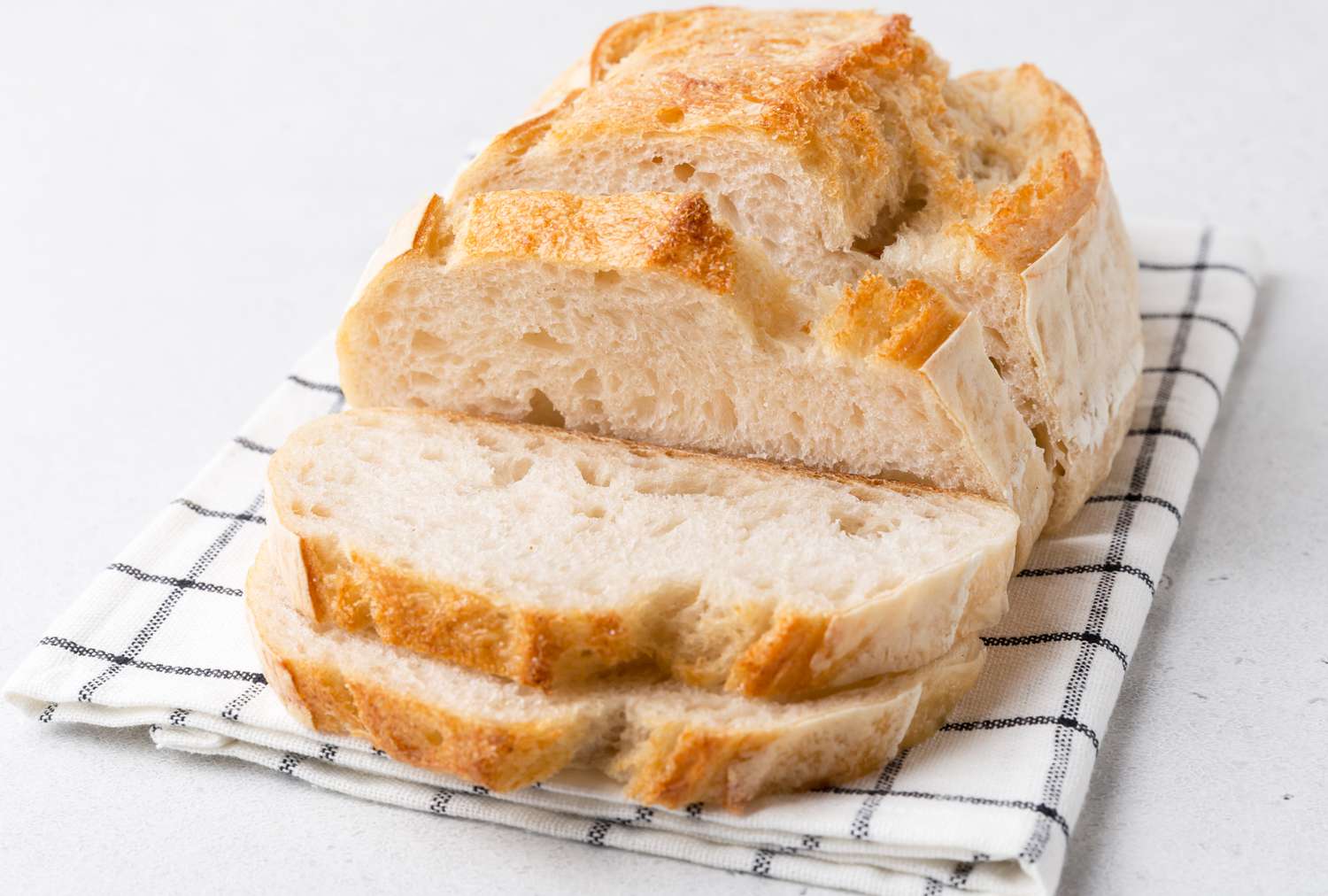 Sliced loaf of bread on a checked cloth