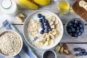 bowl of oatmeal with blueberries, banana, almonds, and milk
