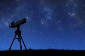 Telescope silhouette against the starry sky