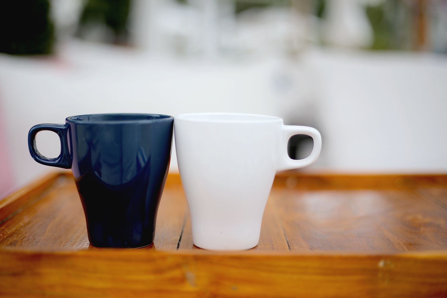 Two coffee mugs side by side on a wooden table
