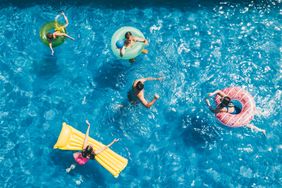 People swimming and floating on inflatables in a pool