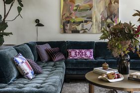 teal velvet sofa with colorful pillows