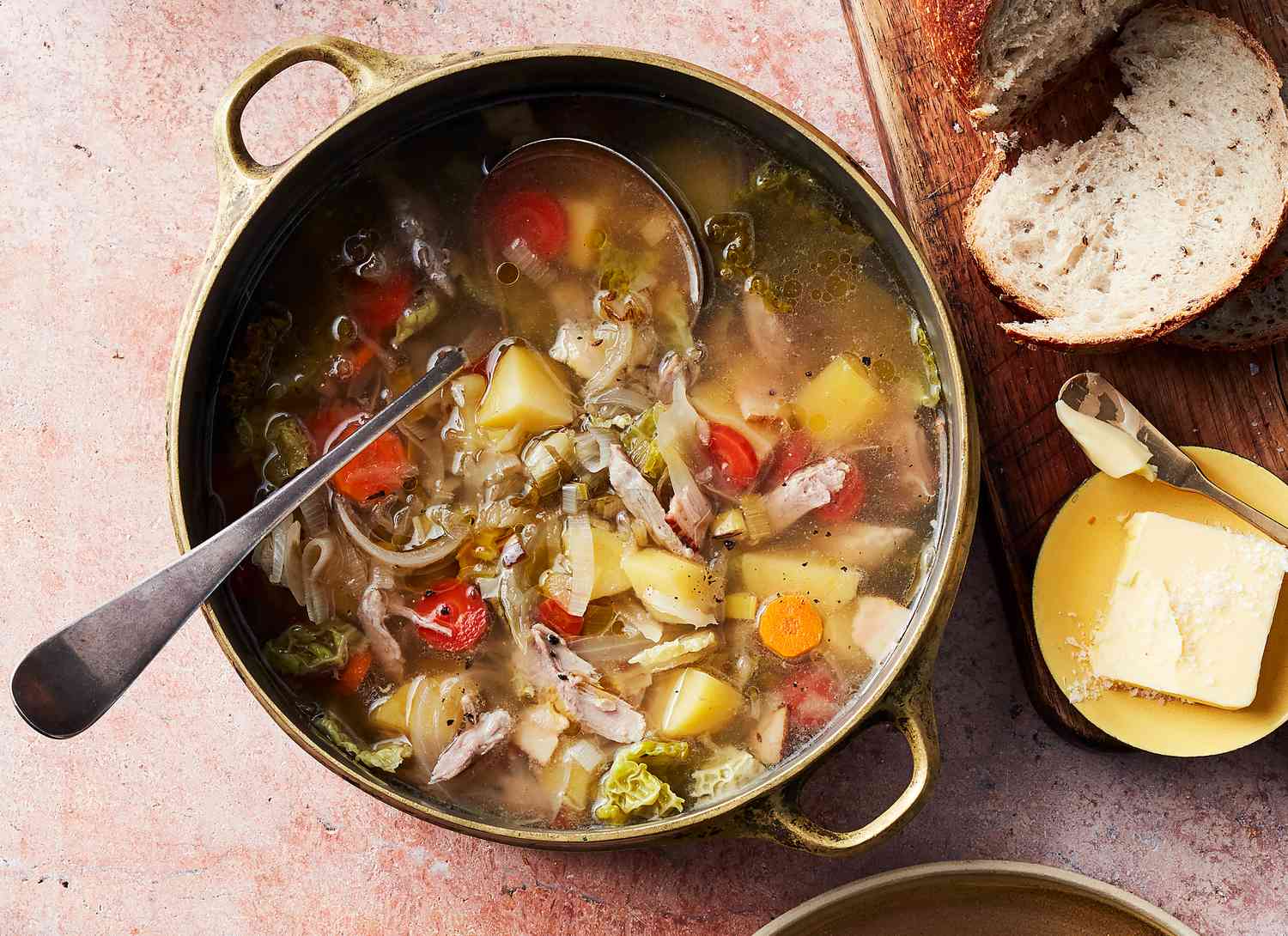 overhead view of a pot of pork cabbage stew with ladle