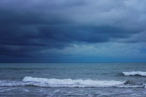 Waves on a beach under cloudy skies