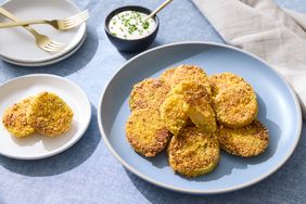 A plate of fried green tomatoes served with a side of dipping sauce
