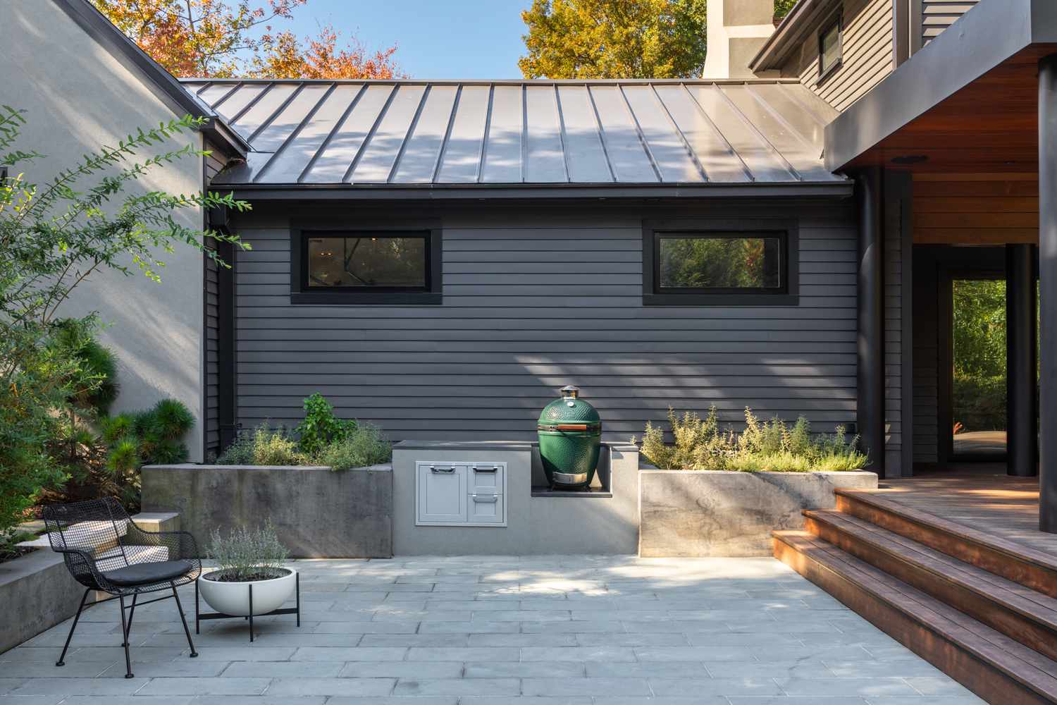 An outdoor patio with a built in stand for a green egg grill