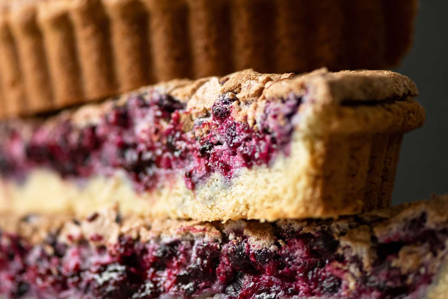 Closeup view of a sliced fruit tart on display showing layers of filling and crust