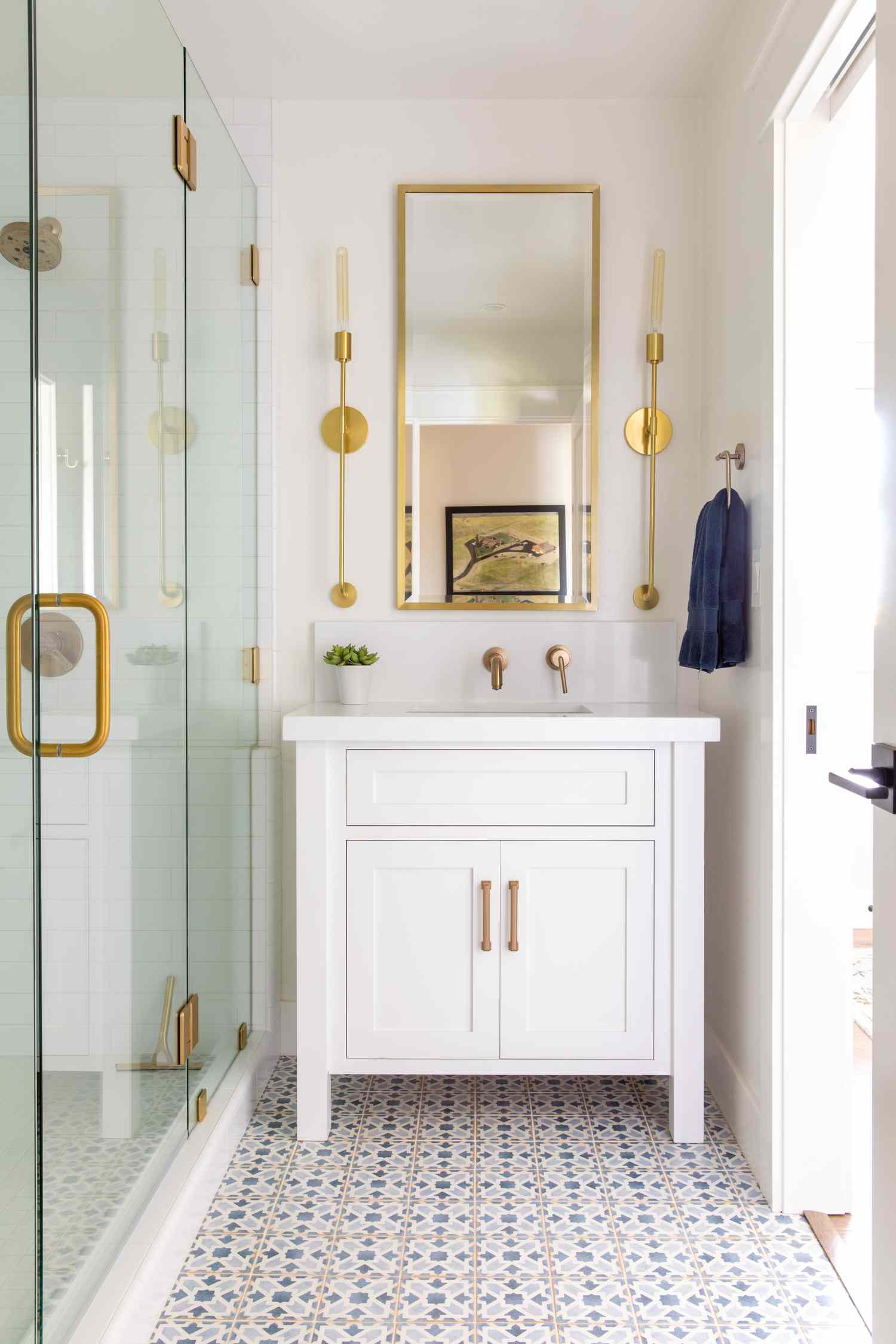 Bathroom with gold mirror and gold sconces