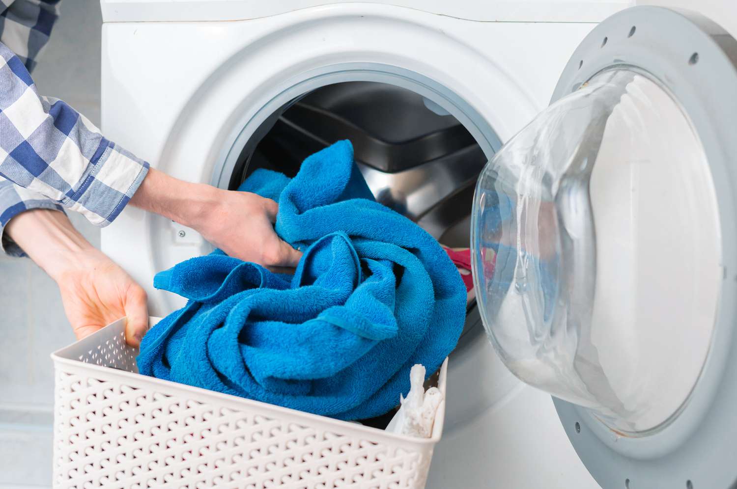Woman washing towels in washing machine