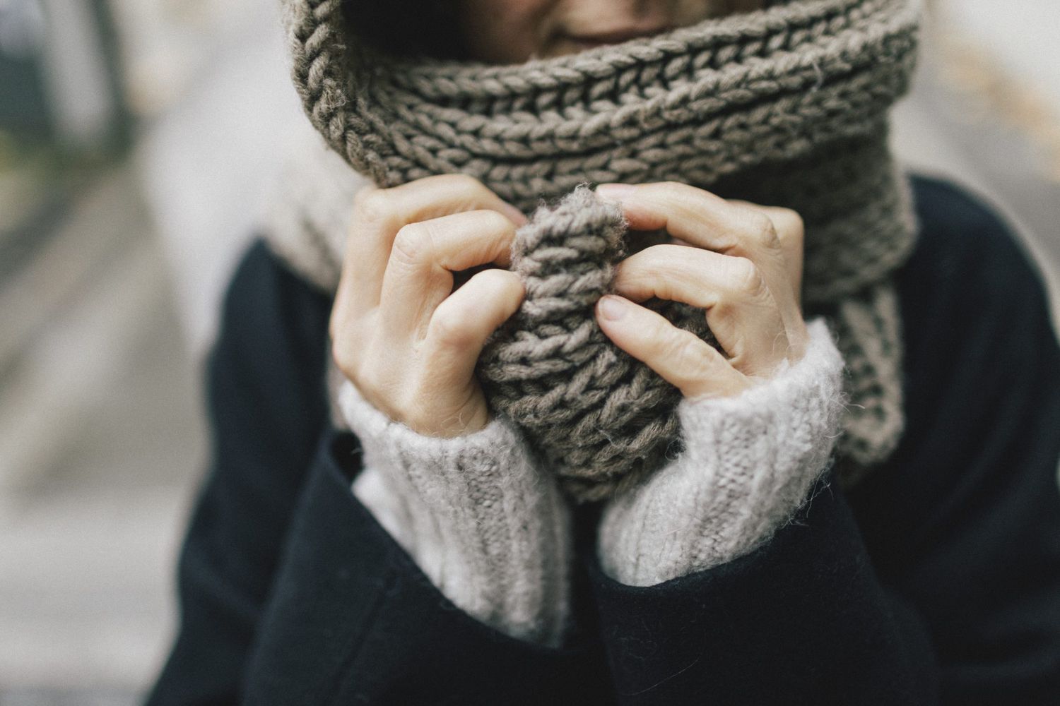 woman's hand holding knitted scarf