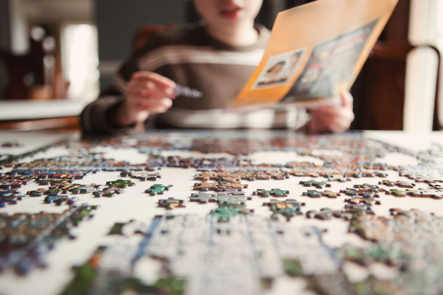 child working on jigsaw puzzle at table